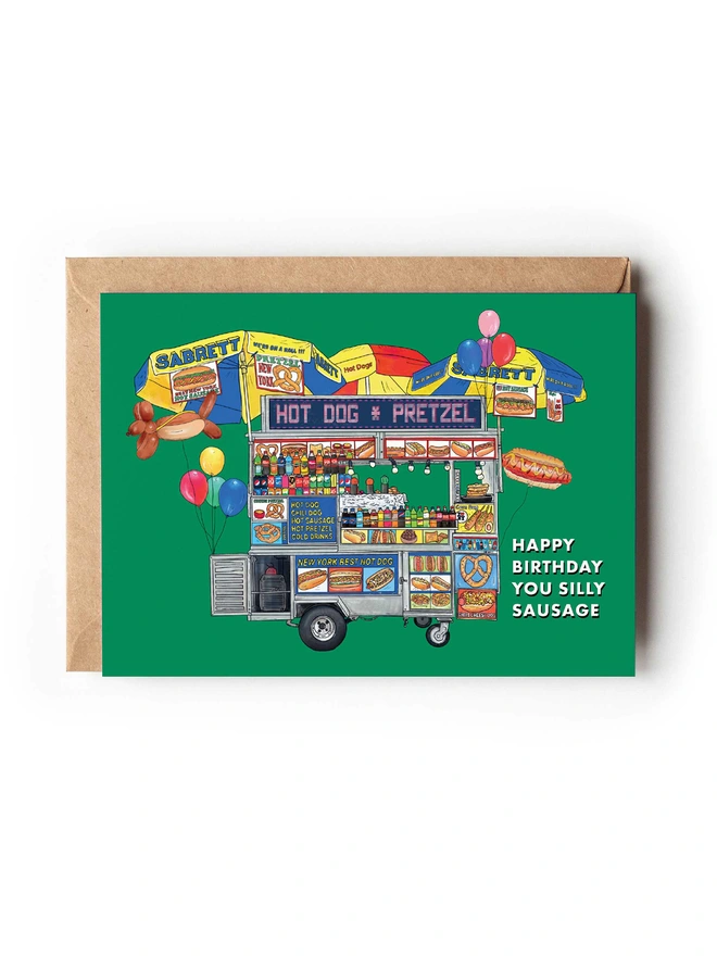 Food-inspired illustrated greeting card featuring a vibrant New York Hot Dog food truck, surrounded by birthday balloons, set against a bold green background. A fun, colourful design perfect for food lovers and anyone celebrating a birthday