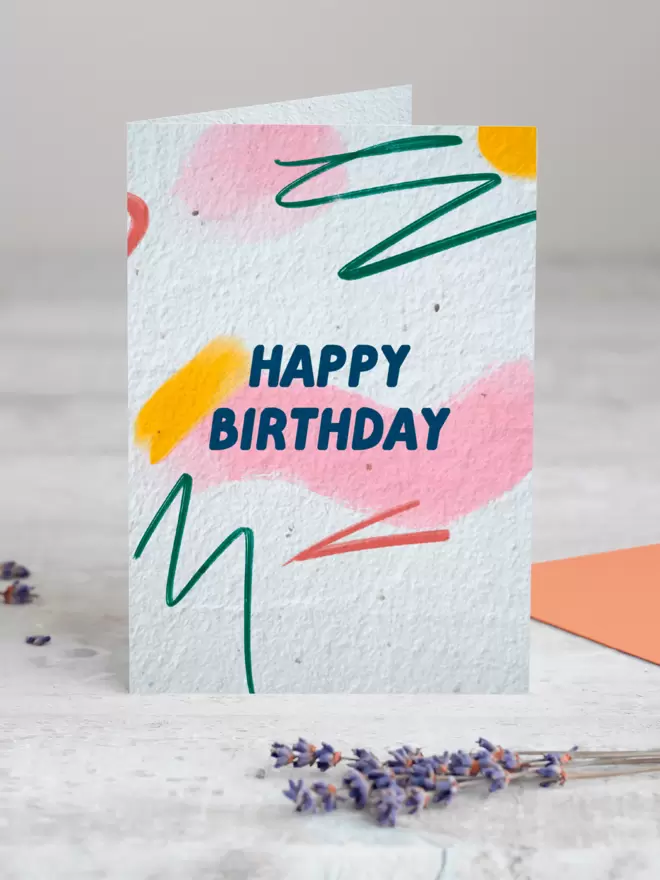 Happy Birthday Plantable Card with an abstract pattern background standing up with Lavender in front