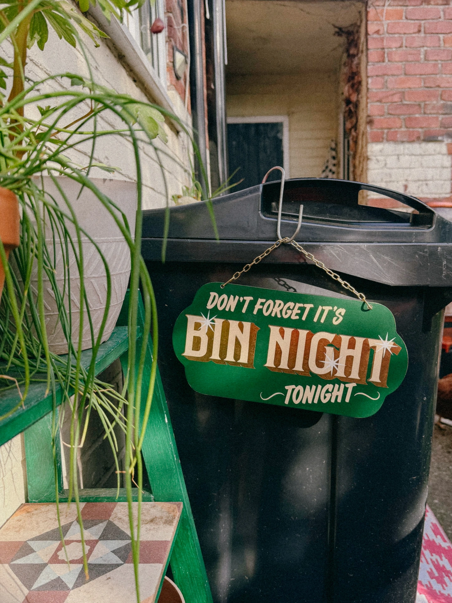 green 'dont forget it's bin night tonight' sign with gold text and hanging chain