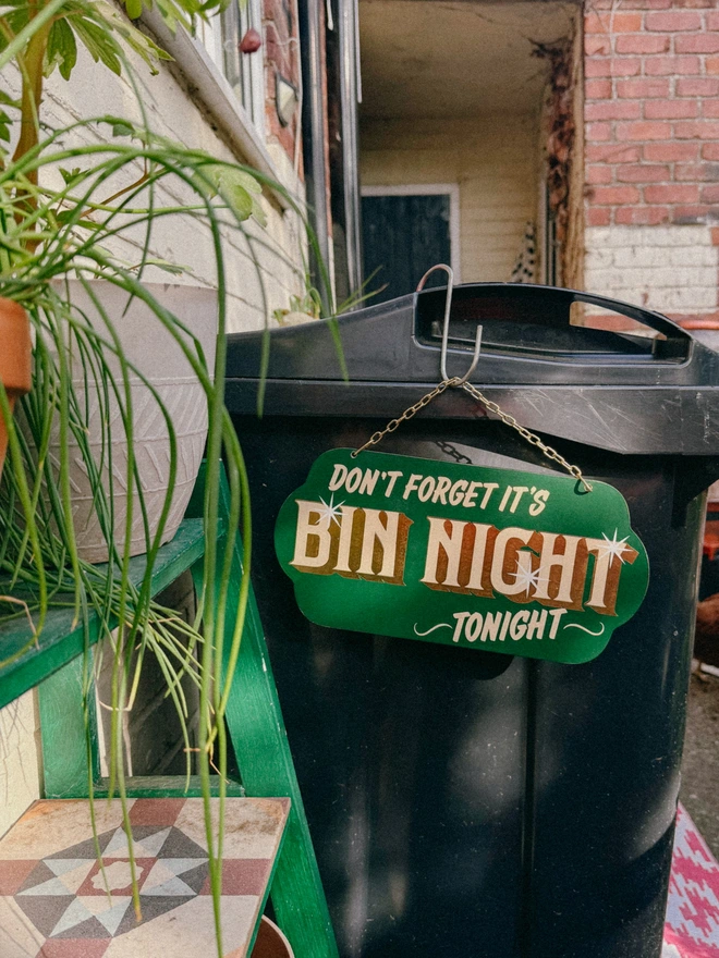 green 'dont forget it's bin night tonight' sign with gold text and hanging chain