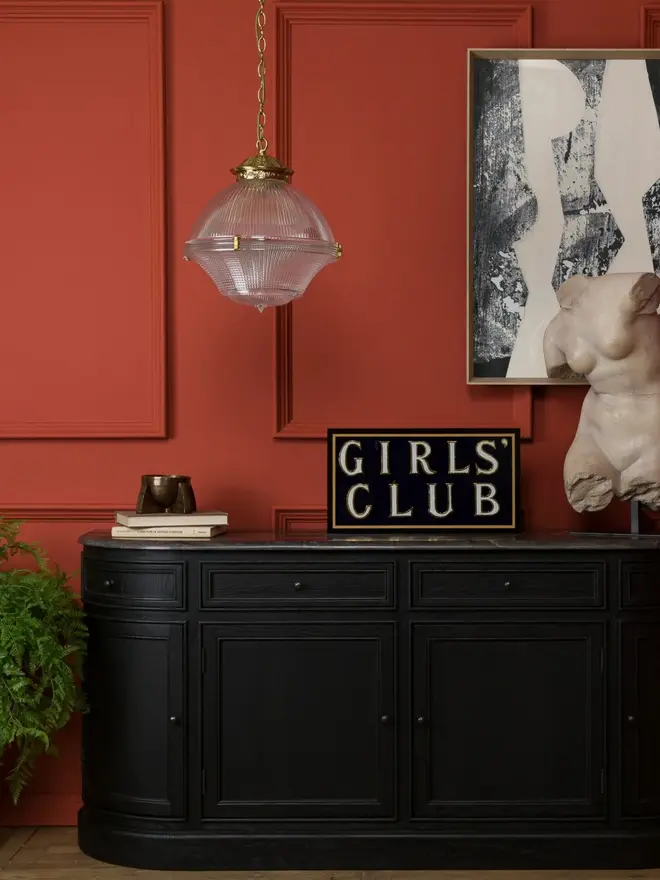 girls club hand painted sign. sign propped up on mantelpiece.