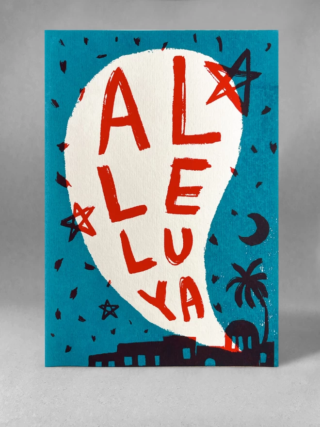 Al-le-lu-ya handprinted Christmas card, two colour screenprint of a biblical town night scene in turquoise and red, in a studio setting. 