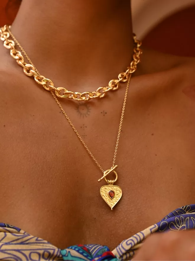 Gold vermeil heart toggle pendant with red stone worn on model with chunky gold choker by Loft & Daughter
