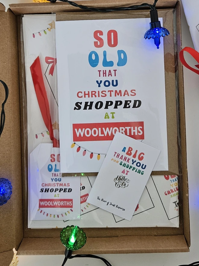  A photograph of the pack in a box with a thank you card for shopping at Holly and Co. In the pack is a sheet of wrapping paper folded, a tag and a card.