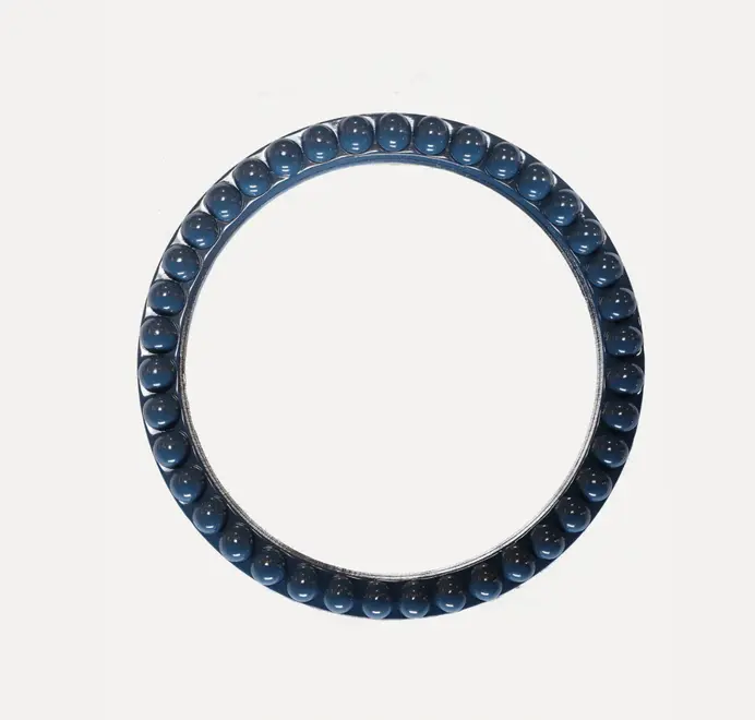 Round oversized bobbin mirror with a decorative bobbin-style wooden frame, hanging on a white wall.