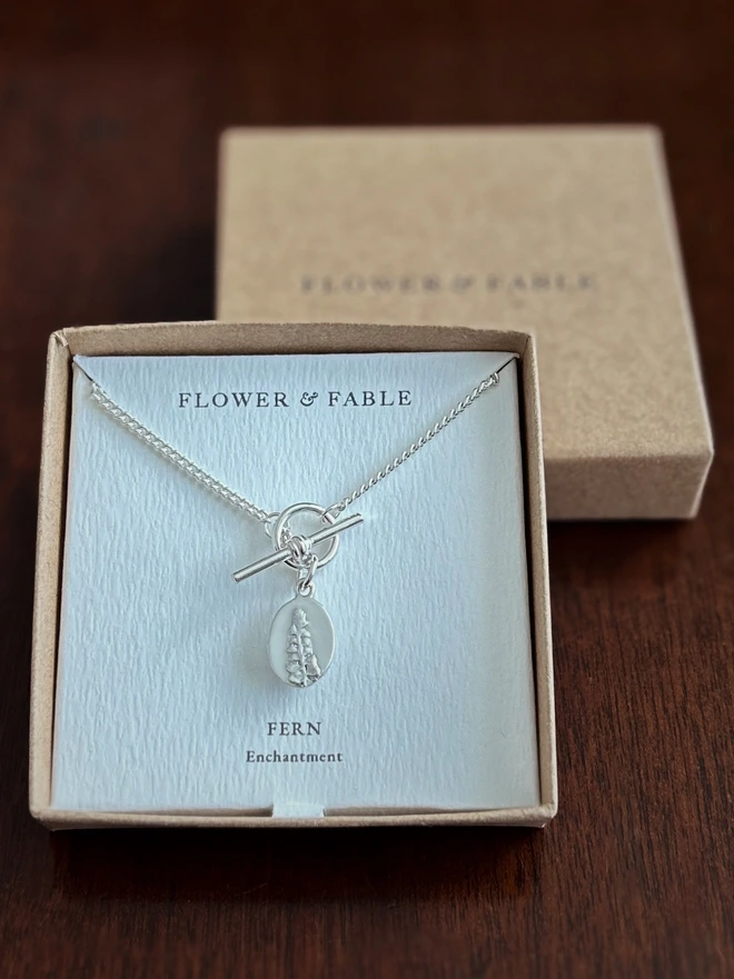 Sterling silver t - bar toggle necklace with a fern medal charm in Flower & Fable packaging