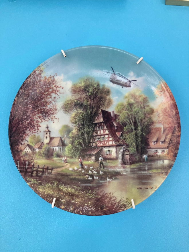 Vintage plate featuring a rural scene with a Chinook Helicopter flying overhead.