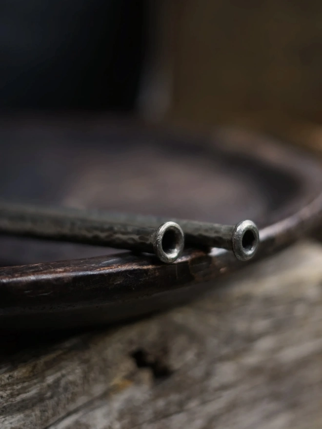 Fire Blower, a pair of metal fire blowers sitting on a wooden tray. 