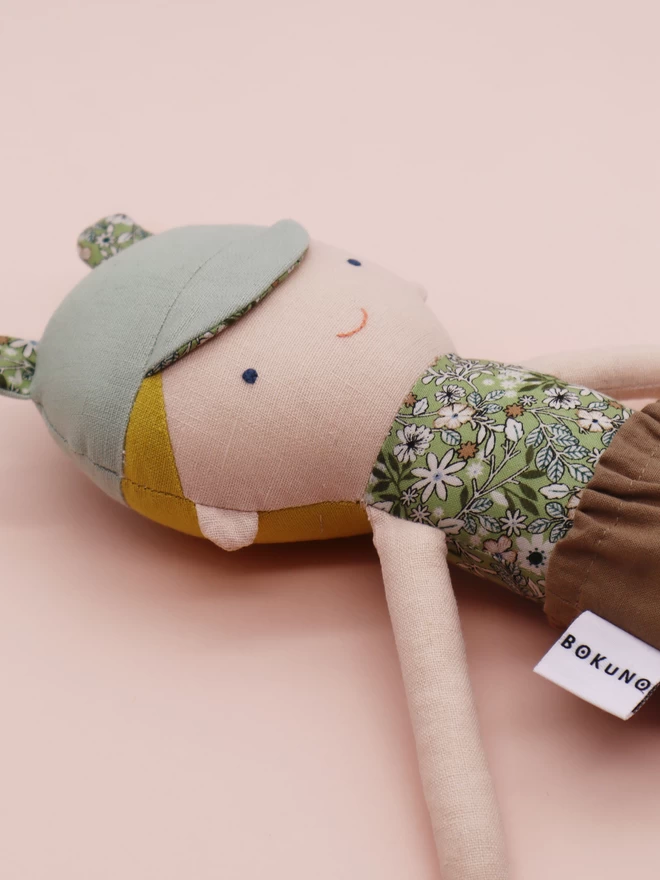fabric boy doll with green cap with bear ears