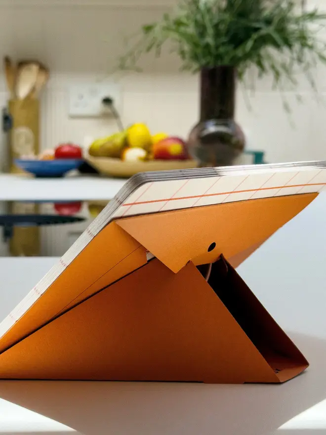 Squared: orange 2027 Monthly Desk Calendar, on a table. 