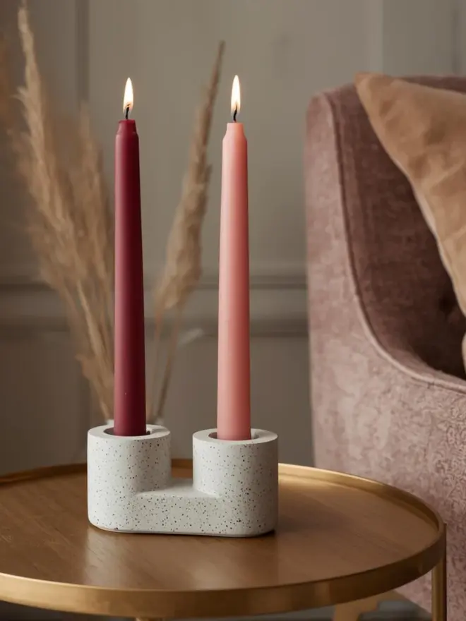 Merlot diner candle in a holder on a brass side table next to an armchair