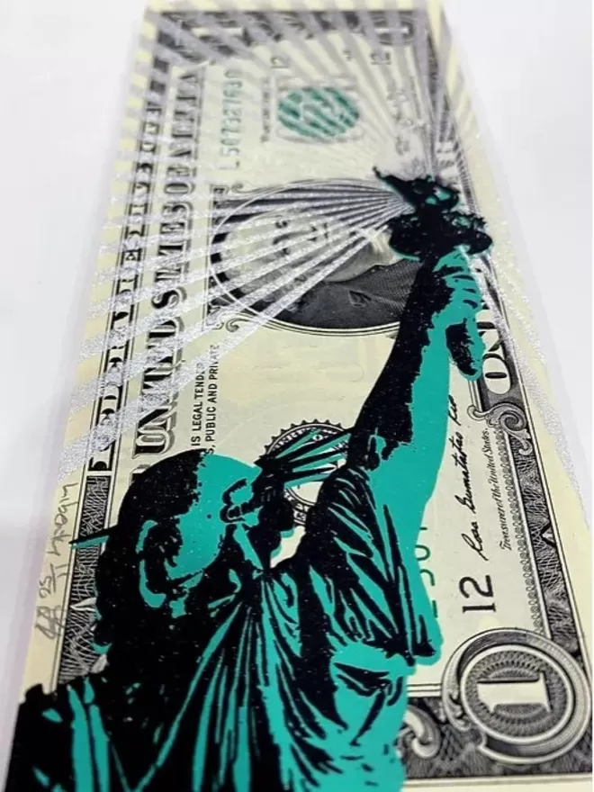 Close crop of a one Dollar Note with Statue of Liberty printed on top in green and black with white glitter rays 