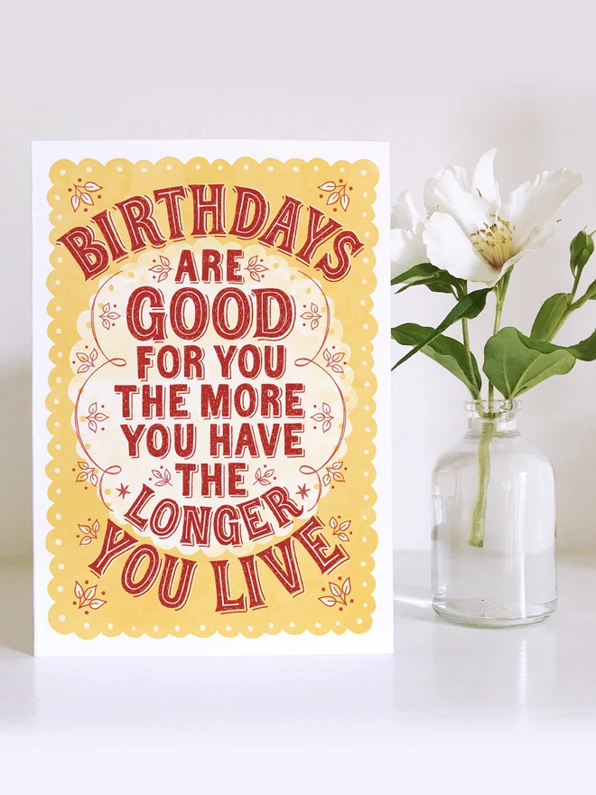 red and yellow birthdays are good for you card with white flower in small vase