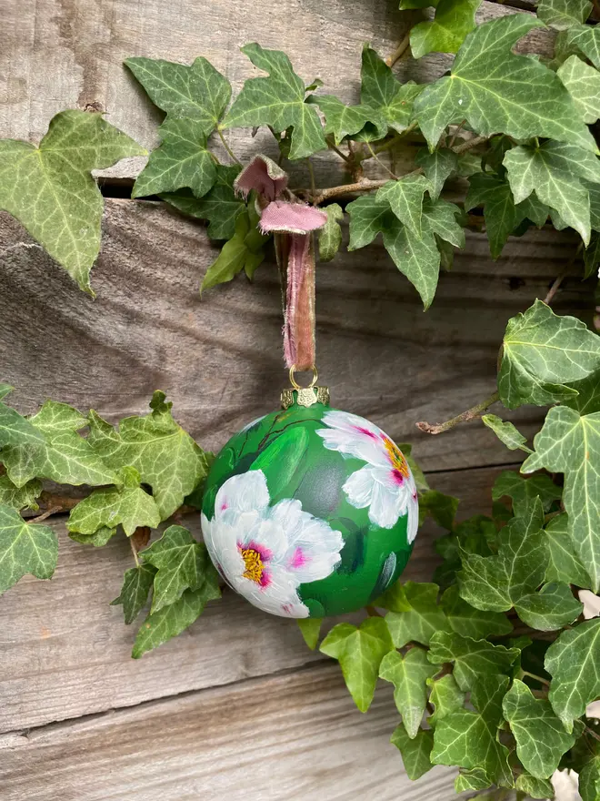 Hand painted floral ceramic bauble green background adorned in tree peony flowers