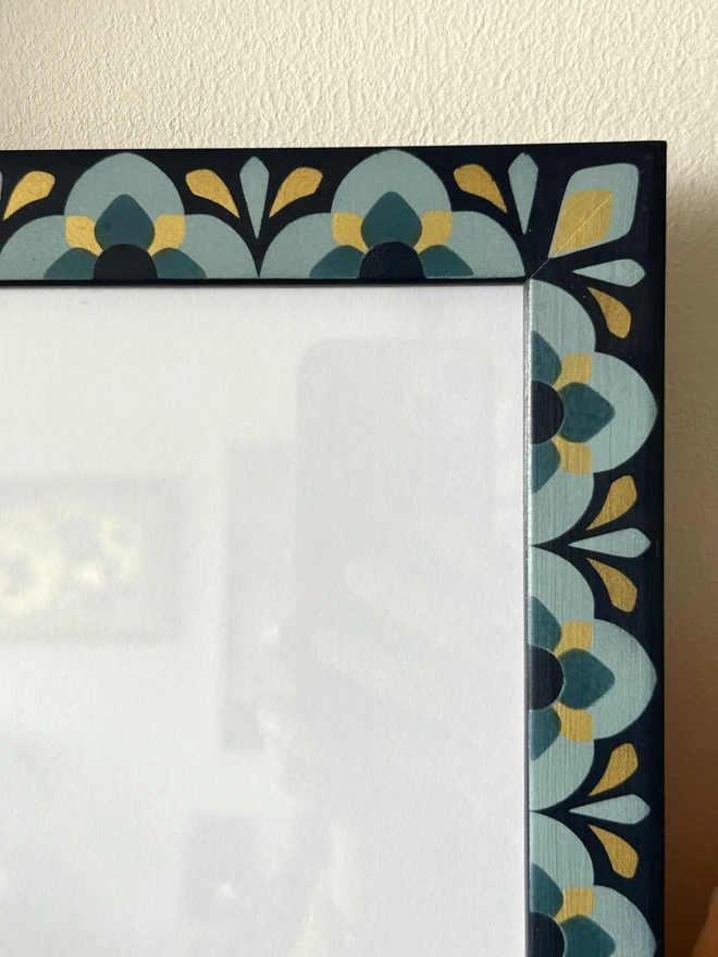 Heavily patterned medium sized picture frame hand painted in shades of blue with gold details