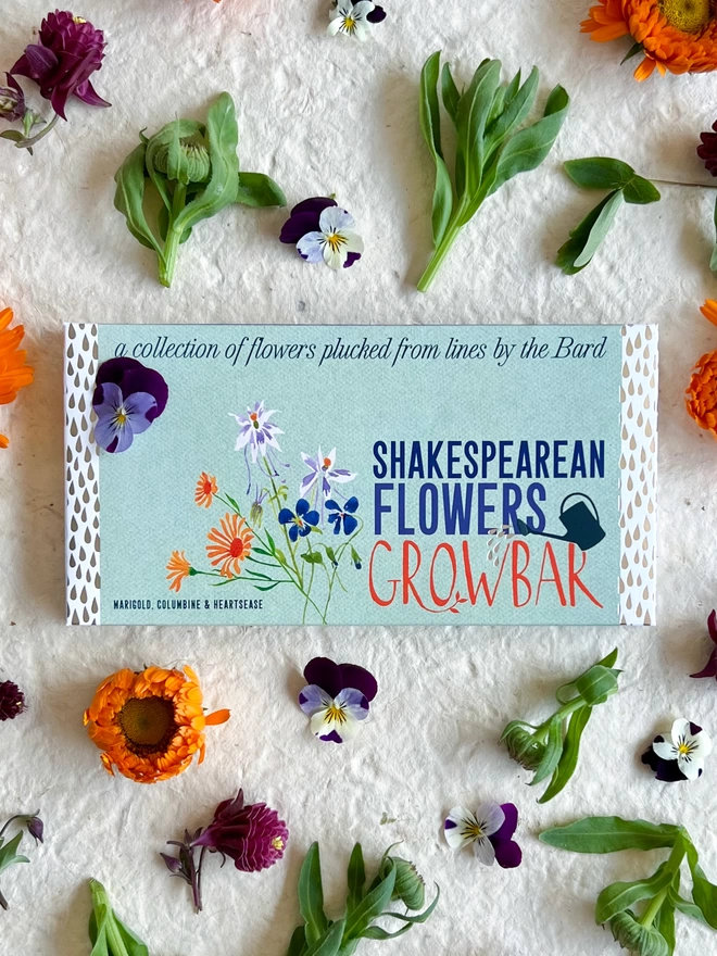 The Shakespearean Flowers Growbar surrounded by large yellow and orange marigold flowers.