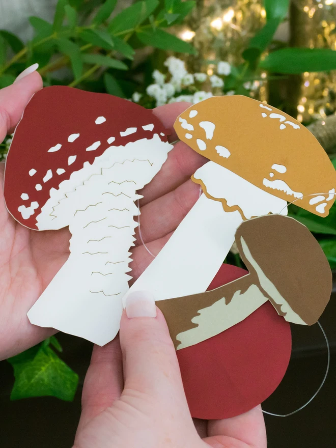 Red and Brown Toadstool Garland Decorations Held in Model's Hands