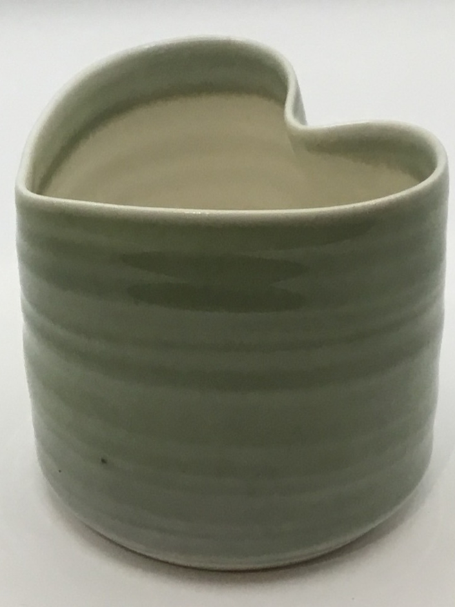  a tea light holder glazed in green on the outside and white on the inside.