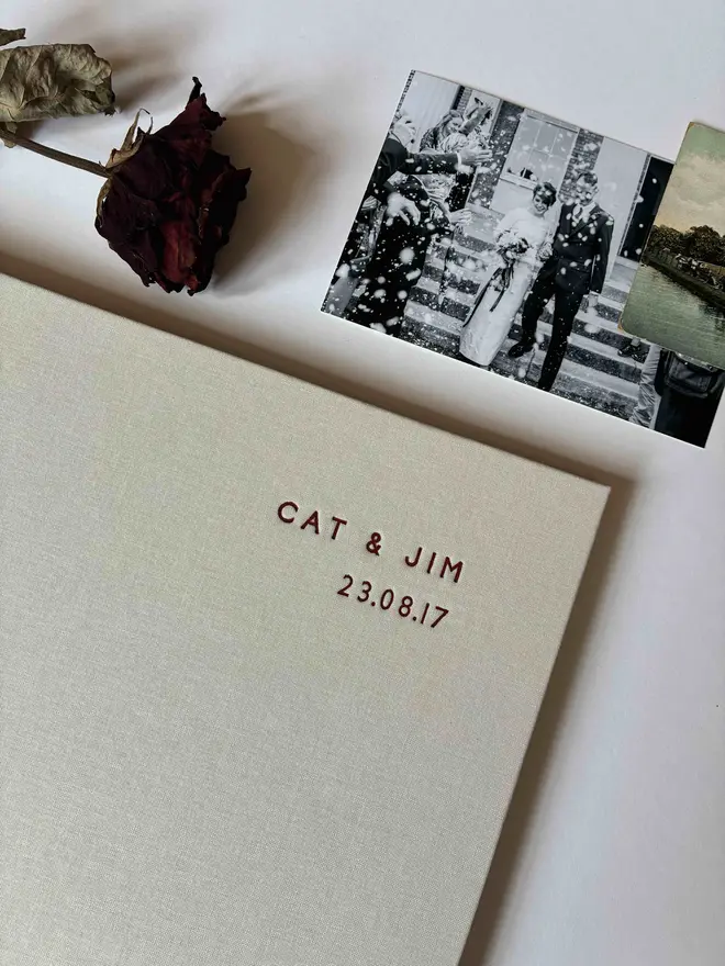 Close up detail of dark red foiled lettering on a handmade photograph album by Keep Collect with dried rose