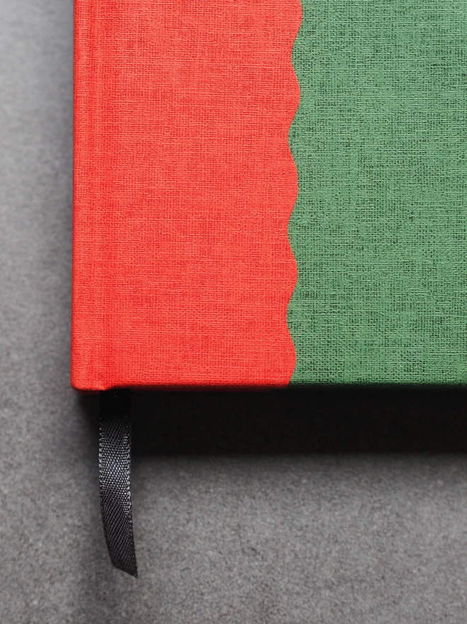 a close up detail of hardcover book with a two tone scallop design in red and green