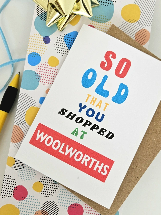 A photograph of the front of a humorous A6 greeting card illustrated using brightly coloured text and the retro shop logo. The text says so old you shopped at Woolworths.