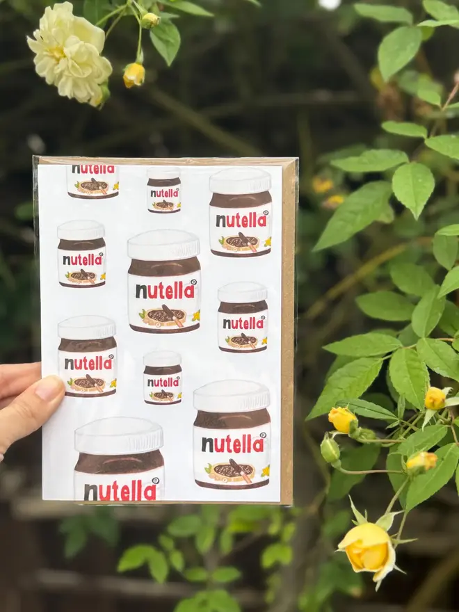 nutella jars illustrated card. card photographed against rosebush background. 