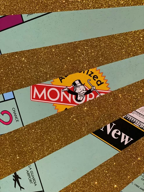 Corner of a Monopoly board close up with gold glitter stripes 