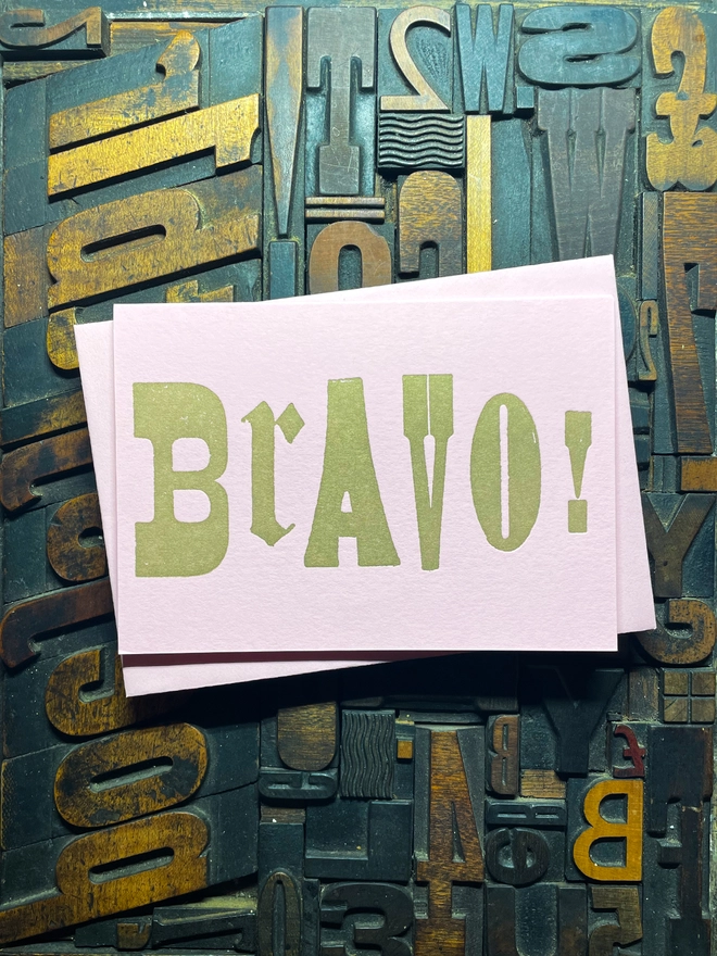 A congratulatory letterpress candy pink card featuring the deep impression word "BRAVO!"; in bold metallic gold letters with a set of colourful envelopes. Perfect for exam results and graduations and other celebrations and milestones.