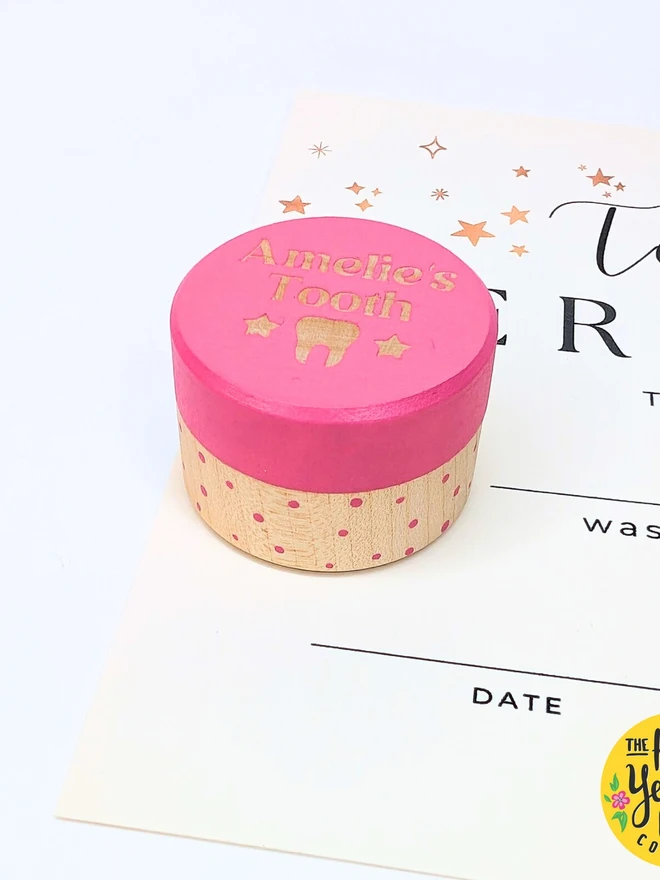 personalised wooden tooth fairy box. a round wooden box with a pink painted lid and personalised text.