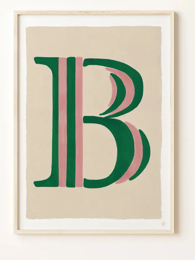 Framed wall art print featuring a large decorative letter “B” in humbug stripes
centered on a white background. 
