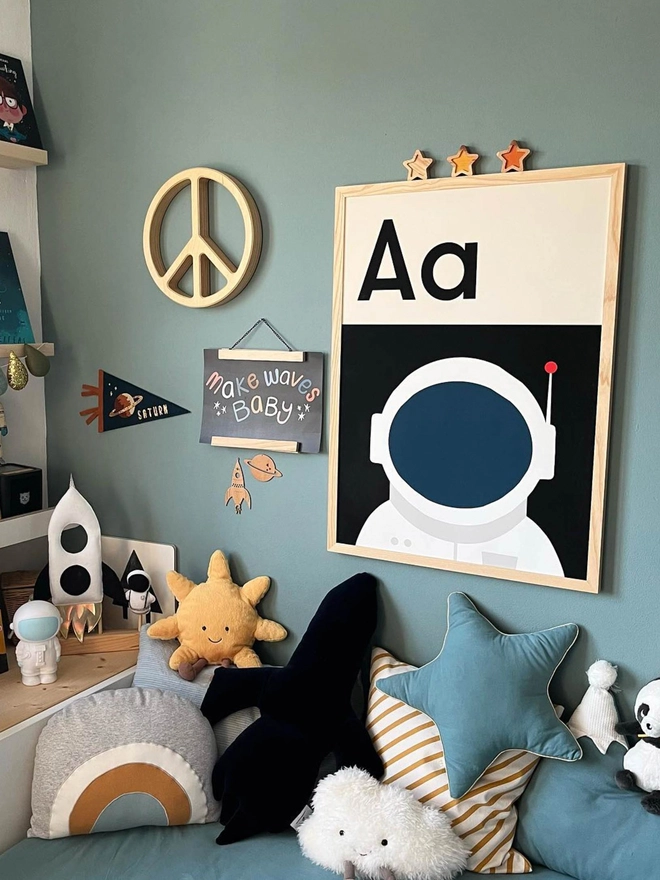 framed illustrated astronaut wall print  with letters Aa on child's bedroom wall surrounded by toys