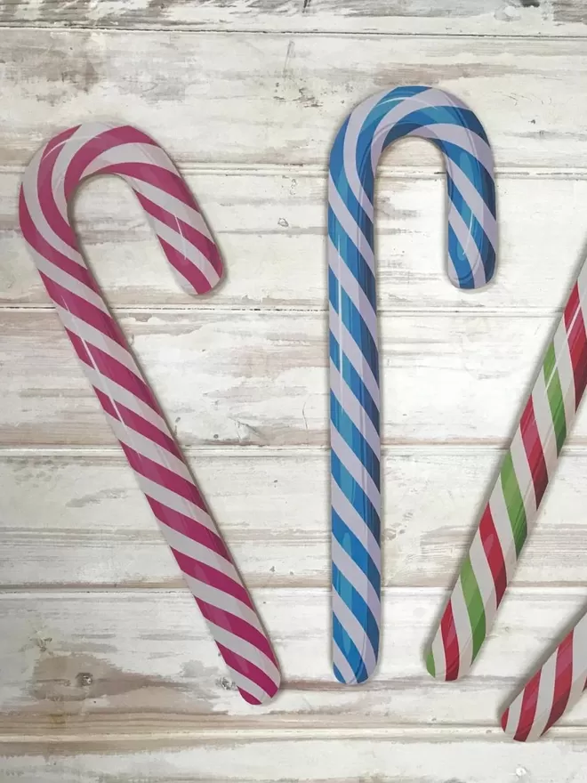 Candy Canes in multiple colours laid out on a wooden board by the Prop Factoroy
