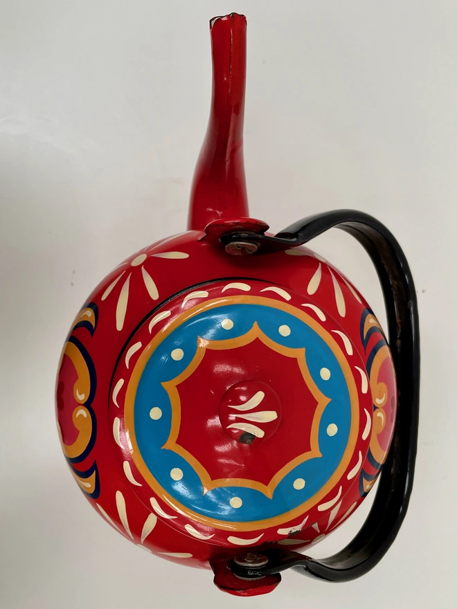 Lid of red 'Tea' teapot, featuring a blue and yellow scalloped edge on lid.