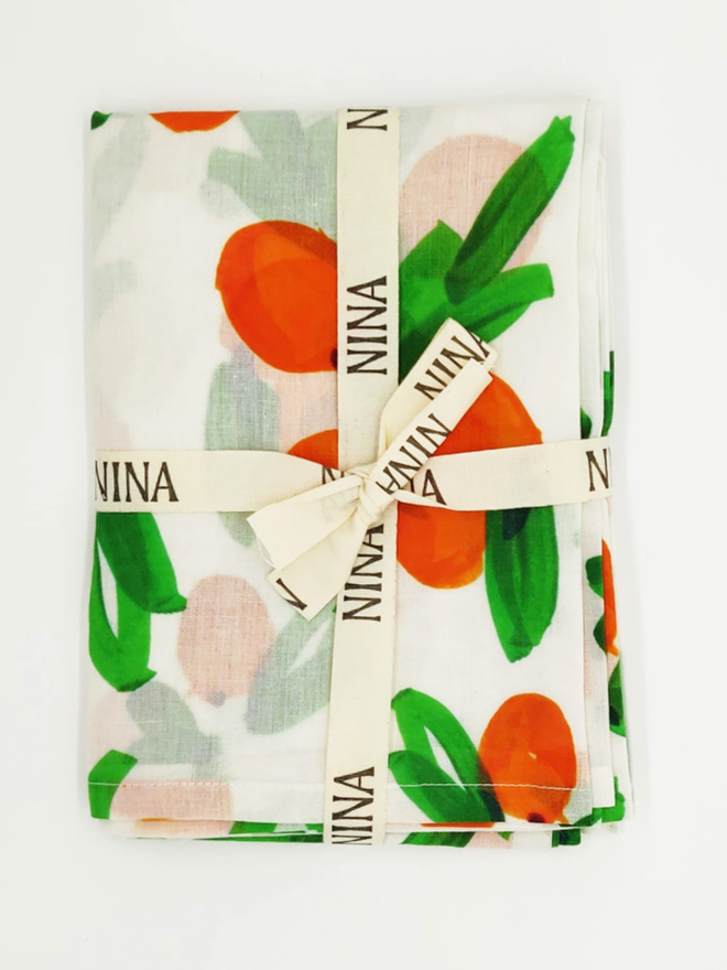 Clementines Muslin. A muslin patterned with clementines, folded.