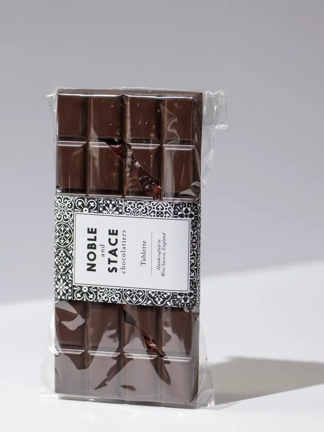 Red chilli chocolate tablette wrapped and standing on a white table. 