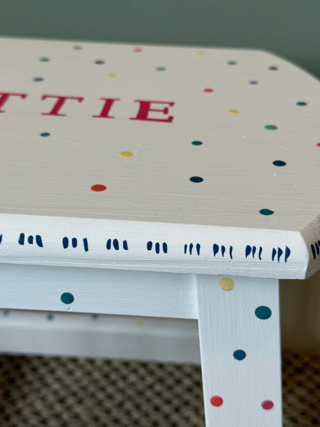 ‘Dottie’ Children’s Hand-Painted Step Stool. A white step stool with multicoloured dots. 