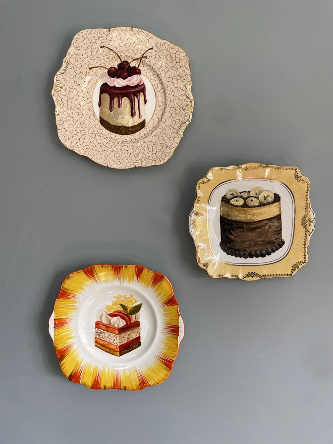 3 painted plates on a blue wall