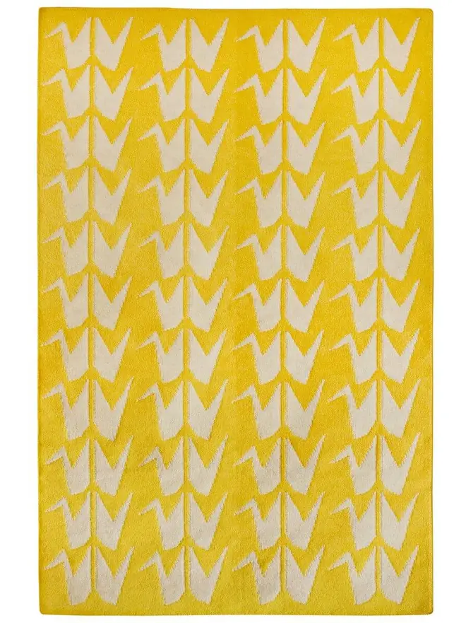 Crane Flatweave Rug, a colourful rug sitting on a plain surface. 