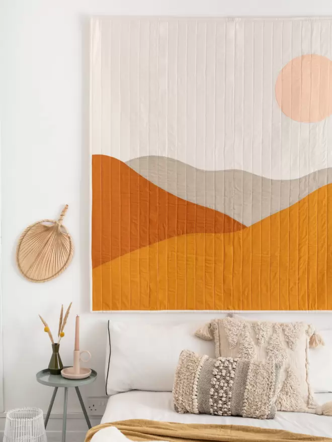 Desert Quilt Hanging On Wall Above Bed