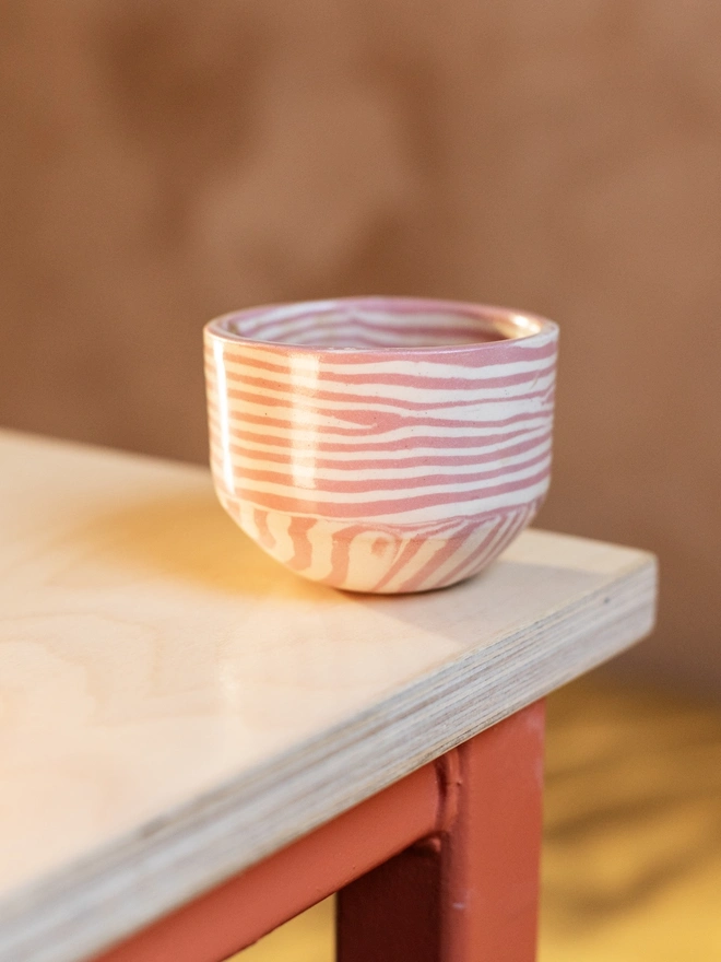 Striped Coffee Cup, a striped coffee cup sitting on a white table top. 