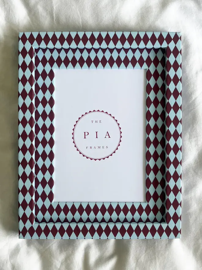 Burgundy & Blue Harlequin Frame, a patterned colourful frame sitting on a plain white surface. 