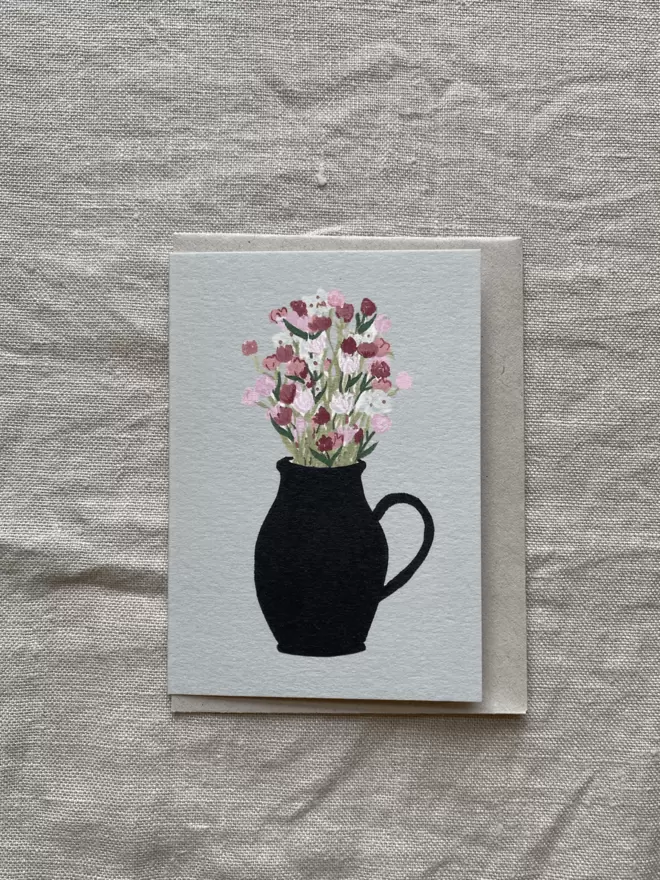 blue greetings card with vase of flowers on