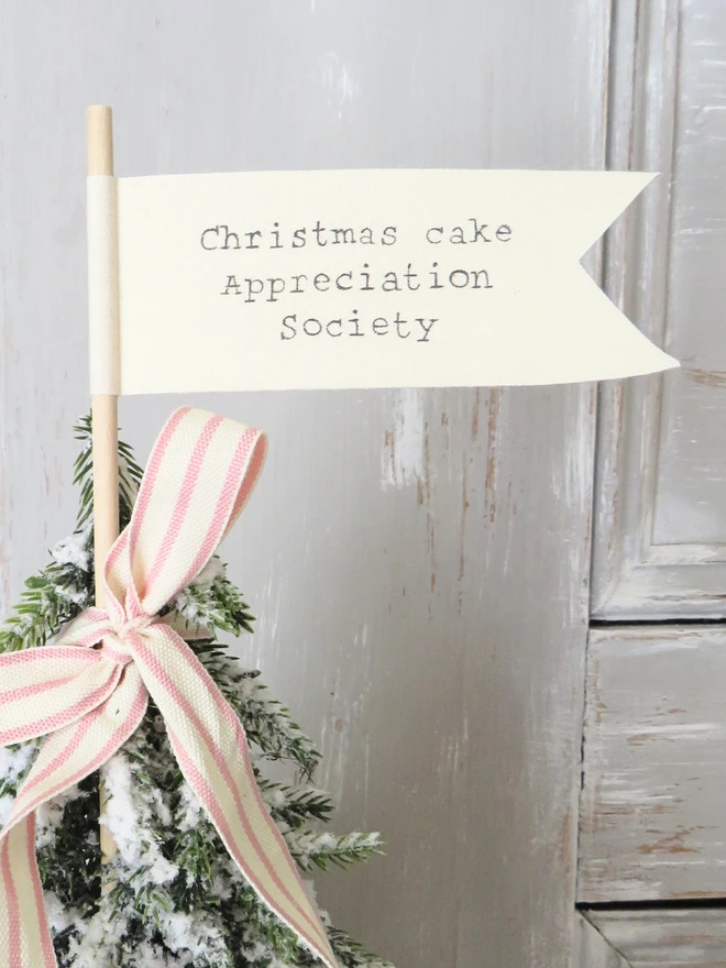 Organic cotton flag hand painted with festive message wrapped around a wooden dowel
