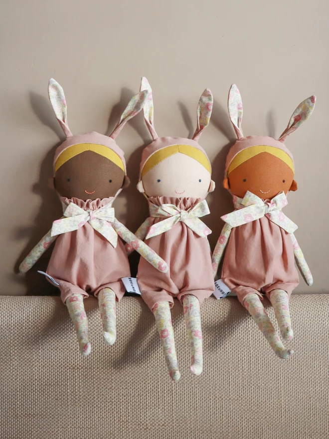 fabric girl dolls with bunny ears in dark black brown and light skin colours 