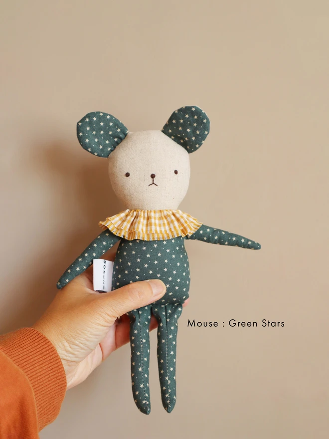 Handmade bear doll with teal fabric featuring small white stars, a yellow gingham ruffle collar, and the name ‘Eli’ embroidered in red on its body. A white tag with the brand name ‘BOKUNO’ is sewn on the side.