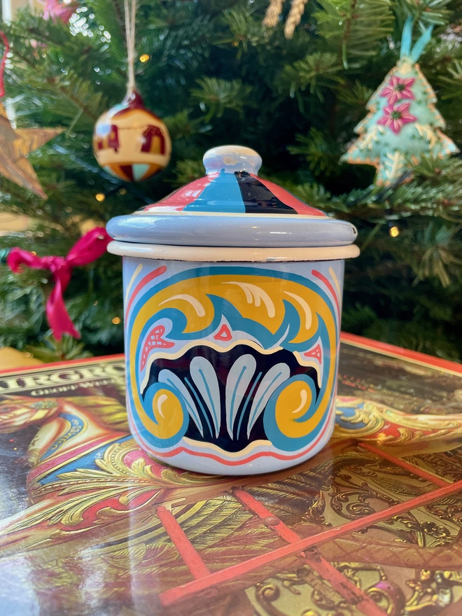 Blue enamel pot hand painted with a fairground design in blue, pink and yellow