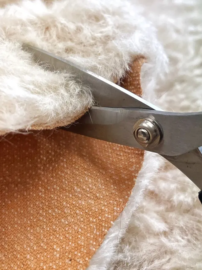 White fabric being cut. 