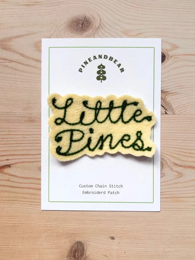 Custom chain stitch patch in cream and green on a white presentation card