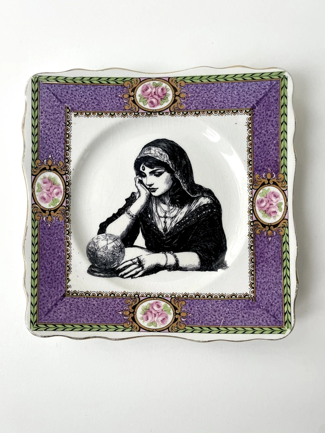 a vintage ornate plate with a pink floral border detail, in the centre i have printed a vintage black and white illustration of a pretty fortune teller reading a crystal ball
