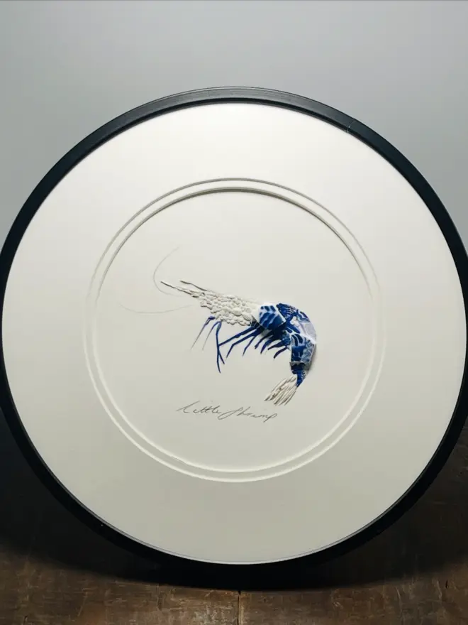 Hand-drawn, painted, mosaic clay, blue vintage Chinese Willow Tree pottery insect on white double mounted card, in a black circular frame.